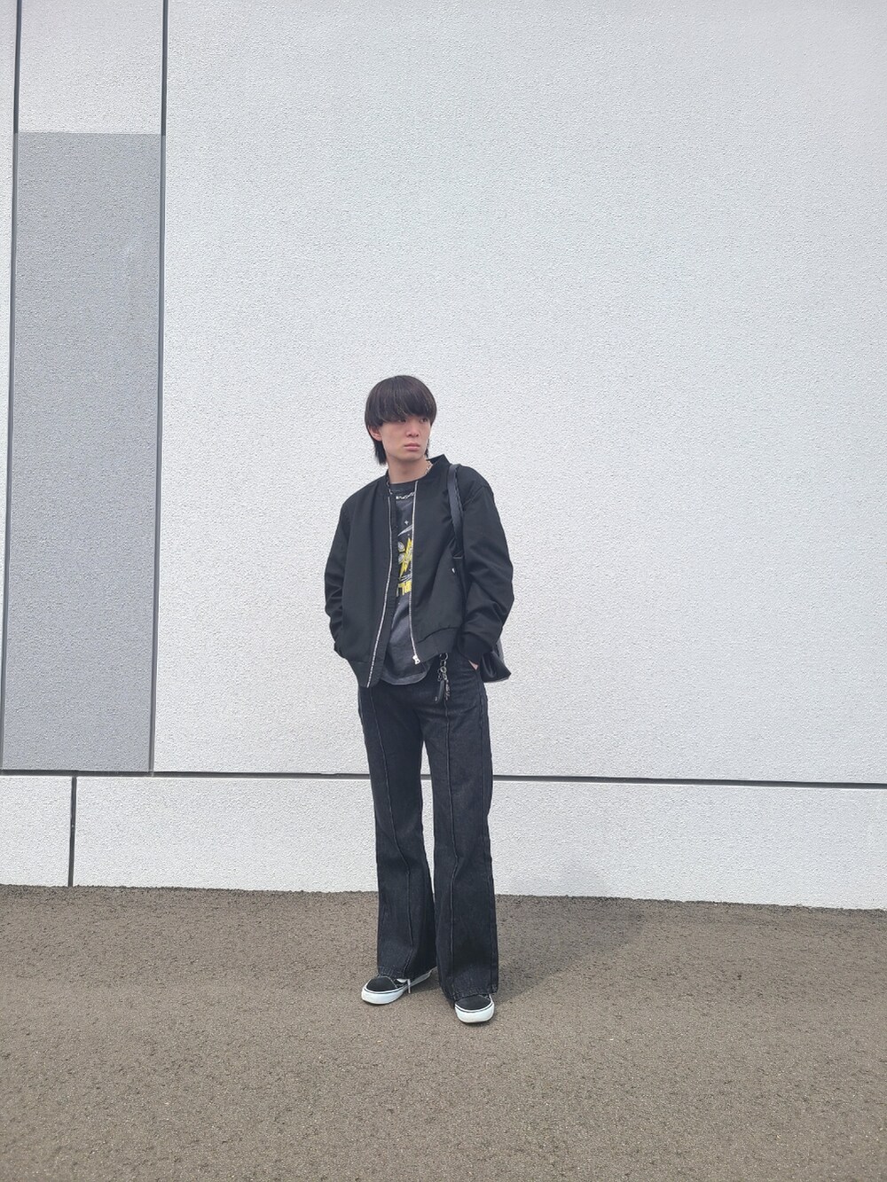 ブラック系のTシャツ/カットソー、ブラック系のデニムパンツ、ブラック系のスニーカーを着用したメンズの春コーディネートの3枚目の写真