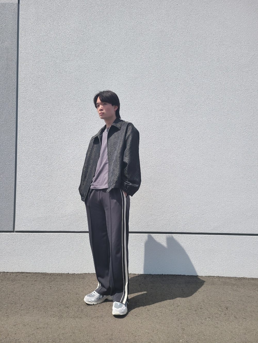 グレー系のTシャツ/カットソー、ブラック系のブルゾン、ブラック系のパンツを着用したメンズの春コーディネートの2枚目の写真