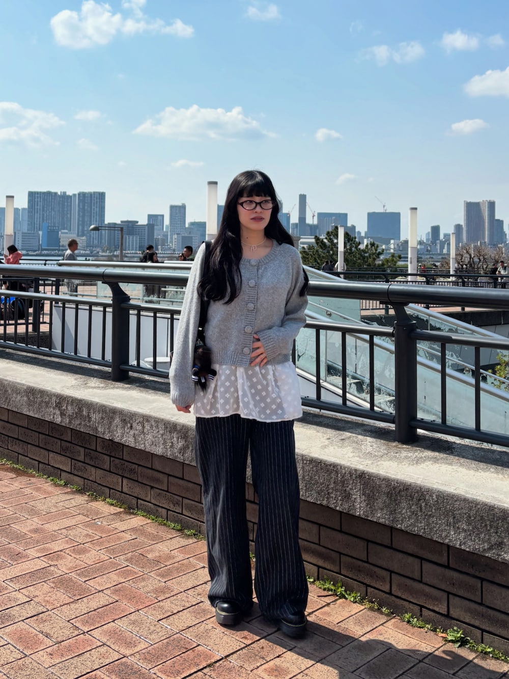 グレー系のトップス、ブラック系のその他パンツを着用したレディースの春コーディネートの2枚目の写真