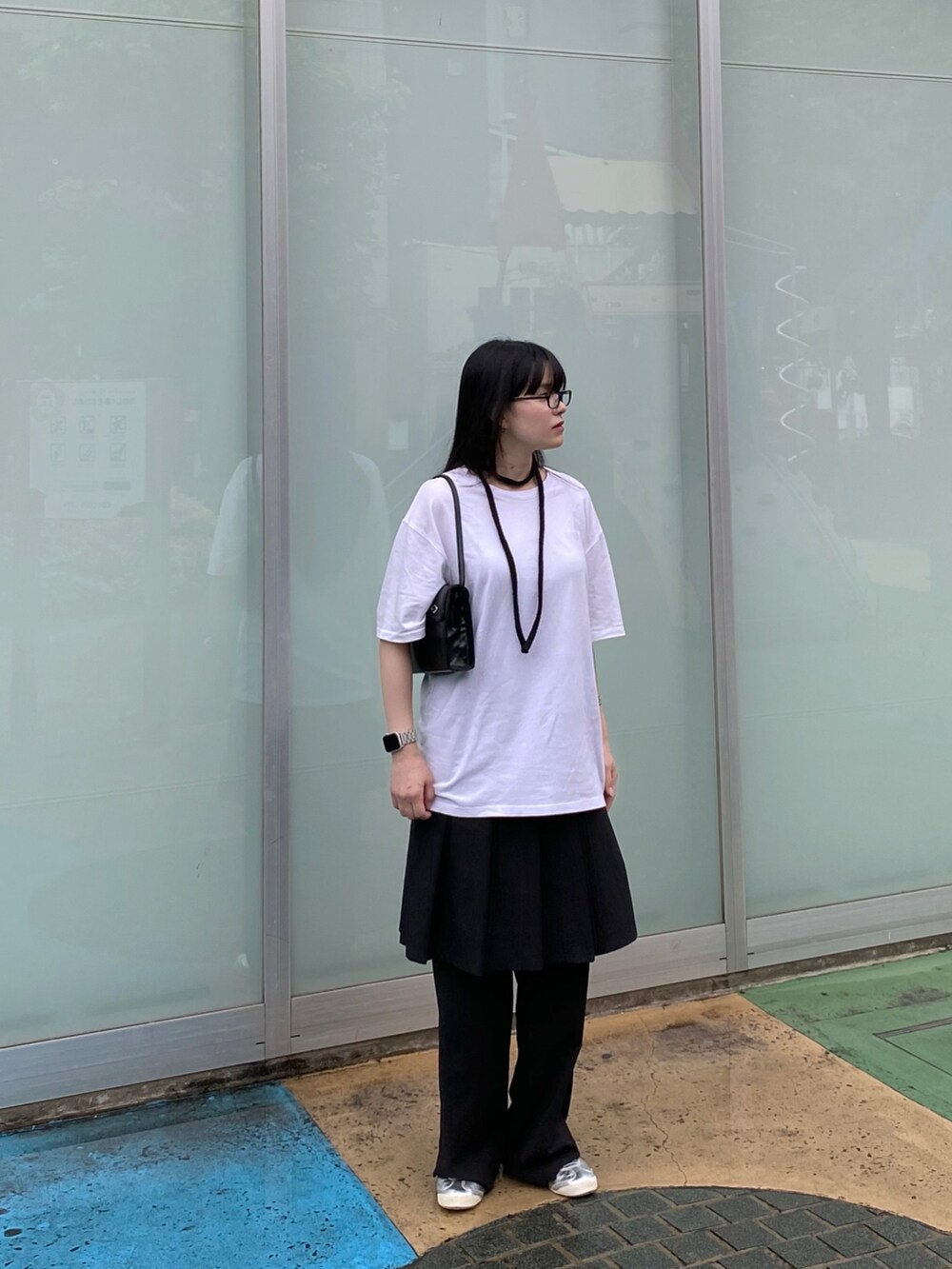 ホワイト系のトップス、ブラック系のバッグ、ブラック系のスカートを着用したレディースの夏コーディネートの3枚目の写真