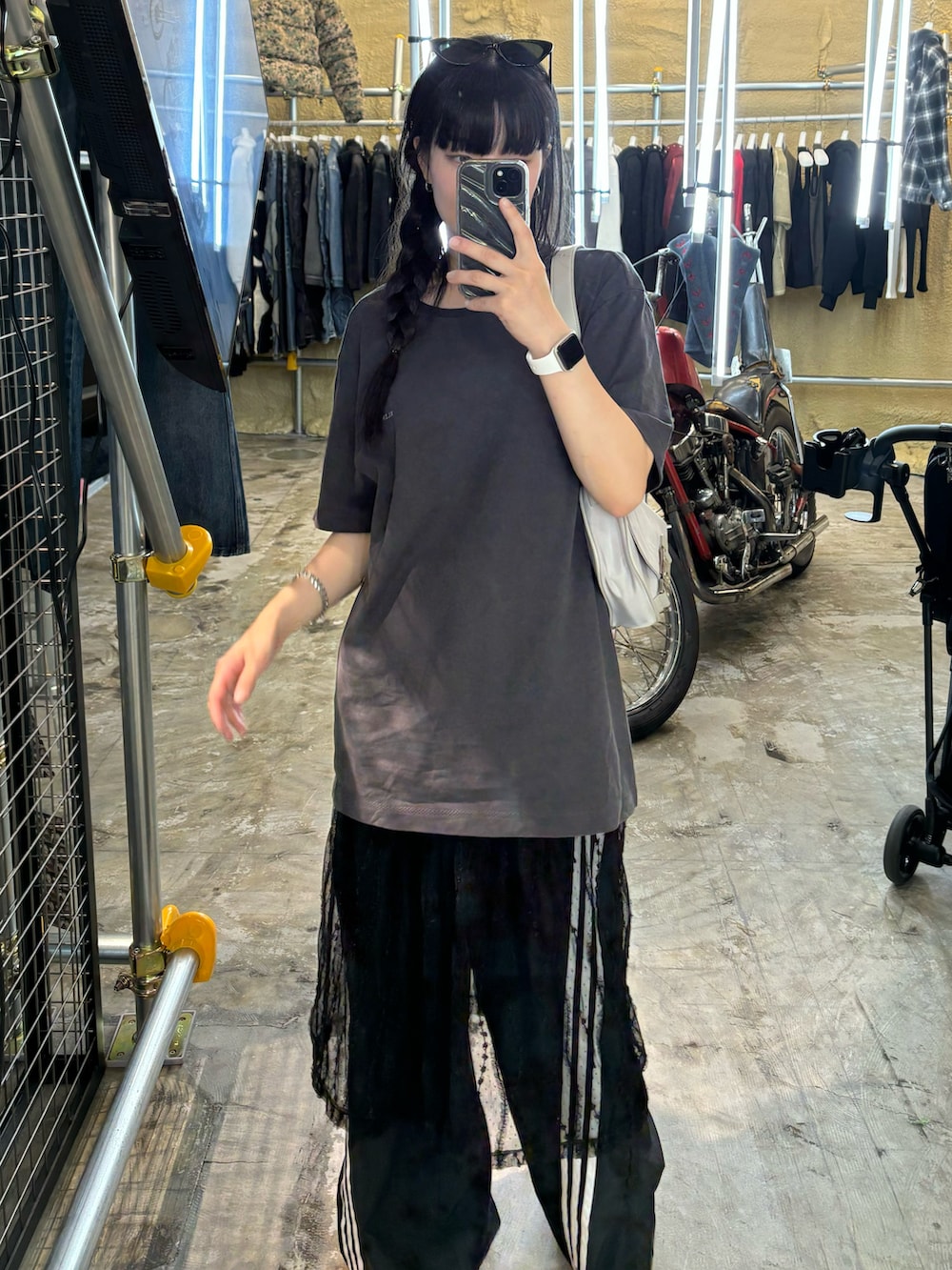 グレー系のトップス、ブラック系のスカート、ブラック系のスウェットパンツを着用したレディースの秋コーディネートの2枚目の写真