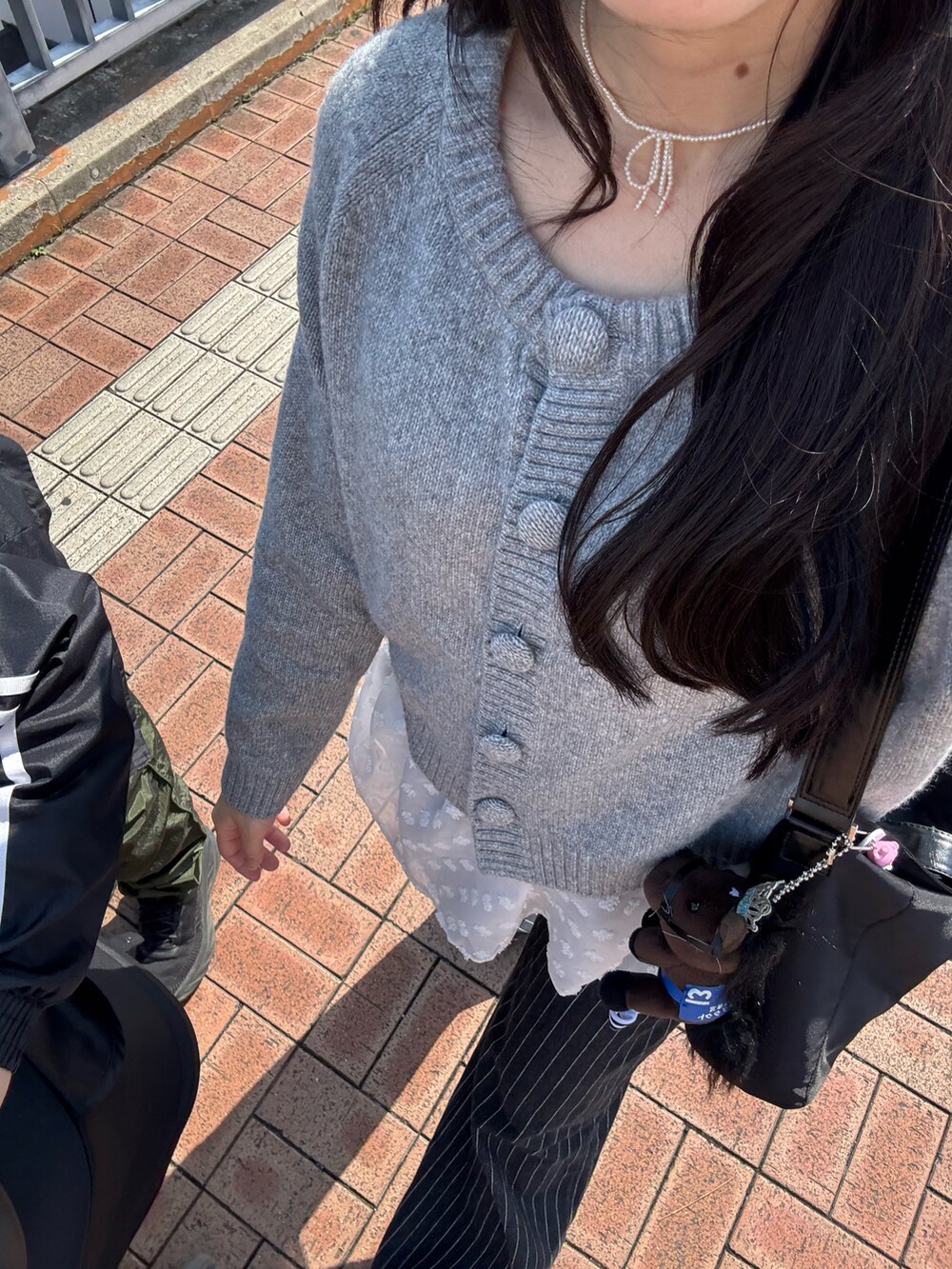 グレー系のトップス、ブラック系のその他パンツを着用したレディースの春コーディネートの3枚目の写真