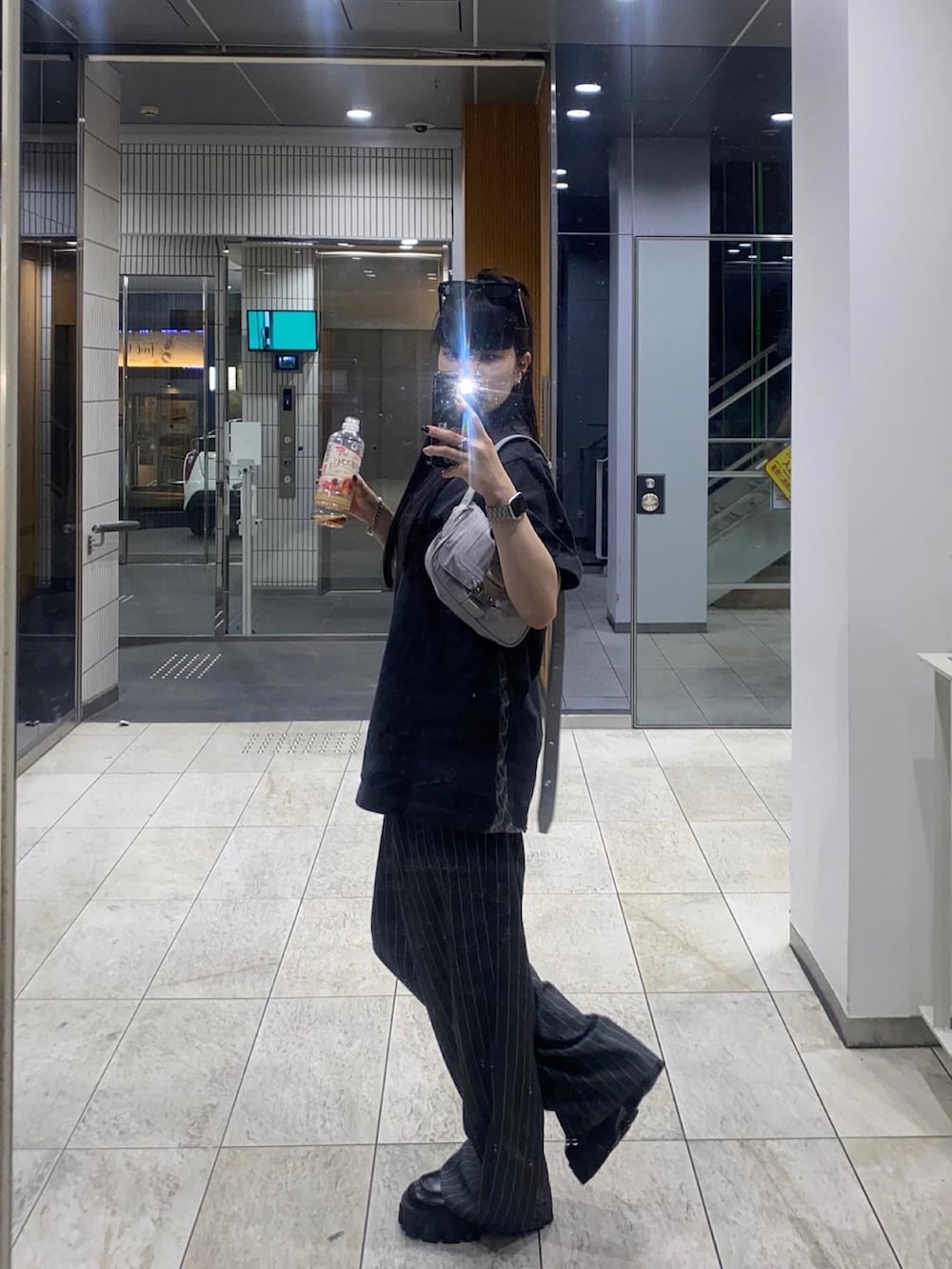 グレー系のパンツ、グレー系のトップス、ブラック系のシューズを着用したレディースの夏コーディネートの2枚目の写真