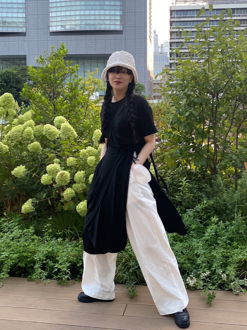 ブラック系のワンピース、ホワイト系のパンツ、ブラック系のシューズを着用したレディースの夏コーディネートの2枚目の写真