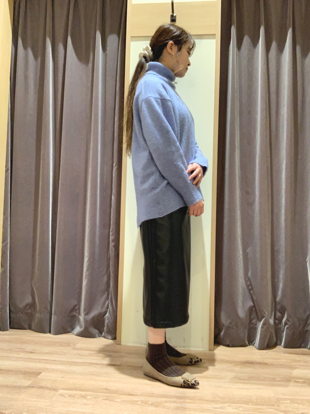 ブルー系のニット/セーター、ブラック系のスカート、ベージュ系のその他シューズを着用したレディースの冬コーディネートの2枚目の写真