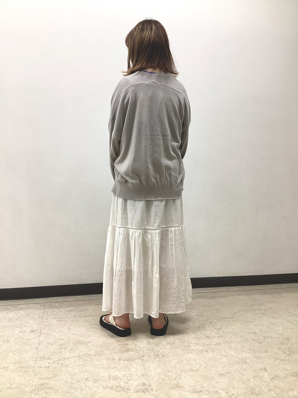 ブルー系のTシャツ/カットソー、グレー系のカーディガン/ボレロ、ホワイト系のスカートを着用したレディースの春コーディネートの4枚目の写真