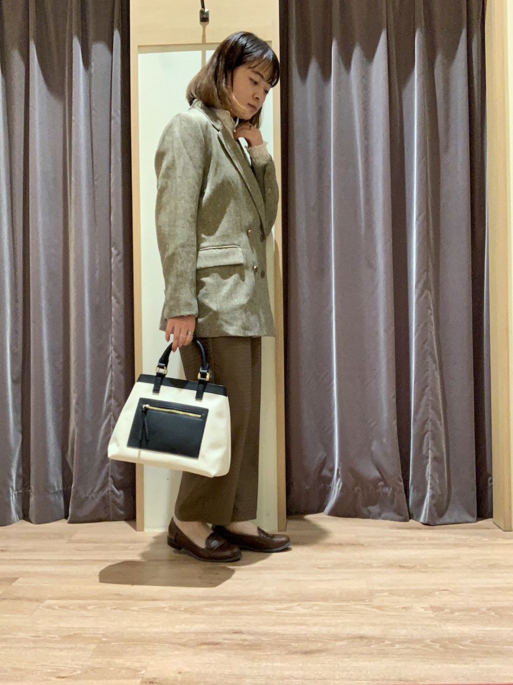 ホワイト系のTシャツ/カットソー、ブラウン系のテーラードジャケット、ホワイト系のハンドバッグを着用したレディースの秋コーディネートの2枚目の写真