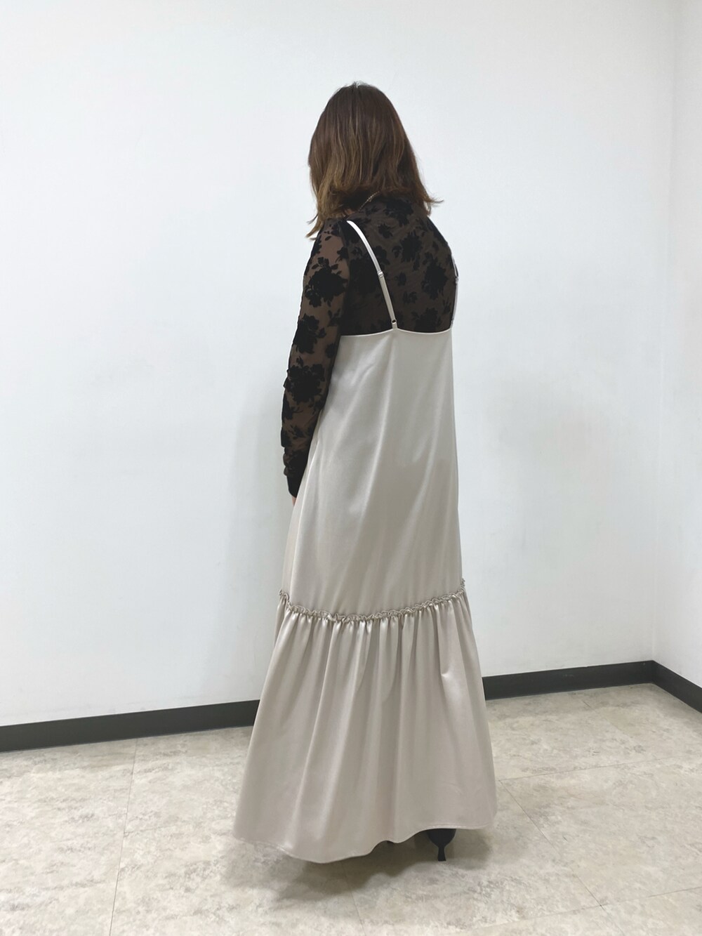 ブラウン系のTシャツ/カットソー、ベージュ系のワンピース、ブラック系のハンドバッグを着用したレディースの秋コーディネートの2枚目の写真