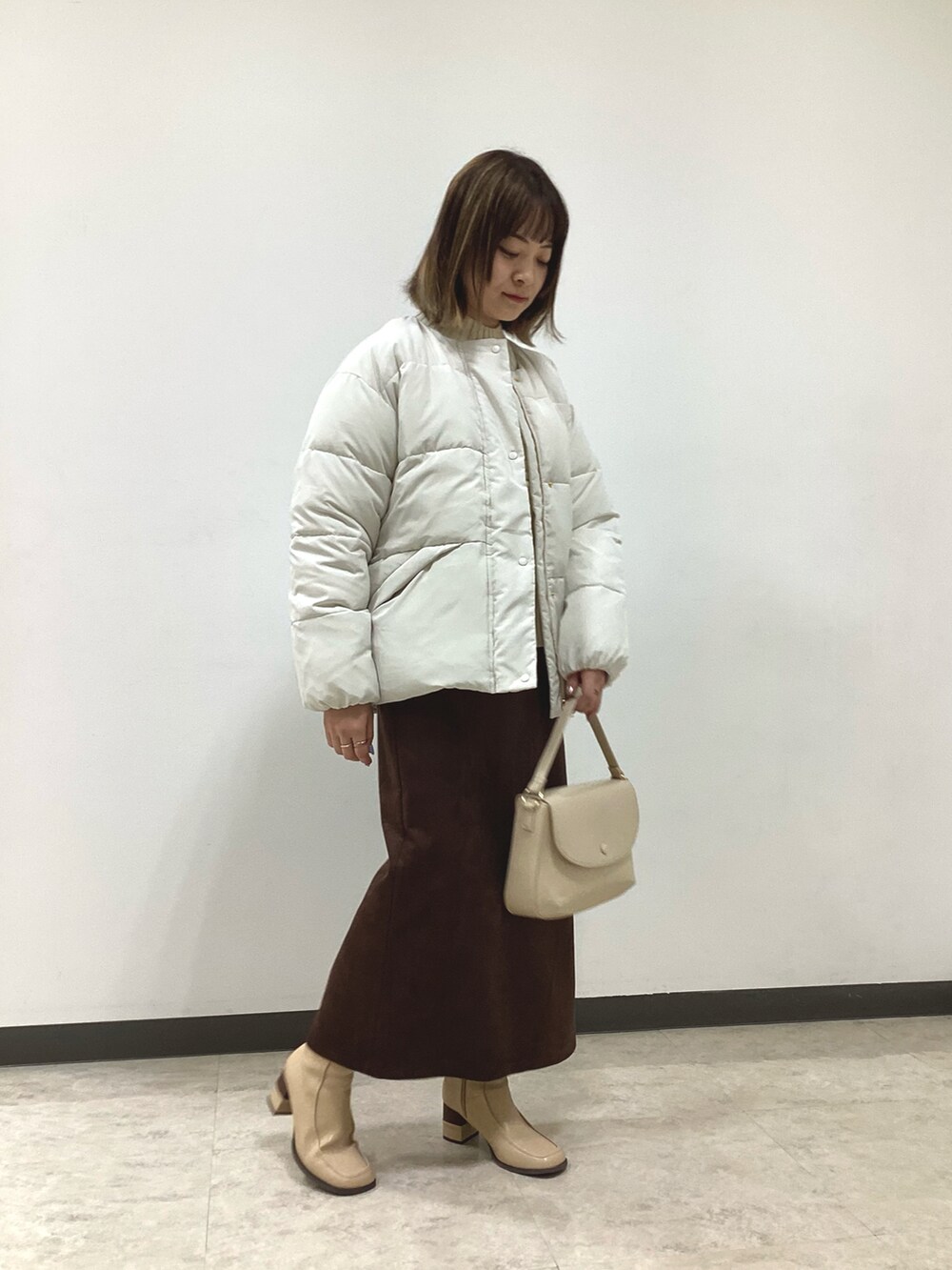 ホワイト系のニット/セーター、ホワイト系のその他アウター、ブラウン系のスカートを着用したレディースの冬コーディネートの3枚目の写真