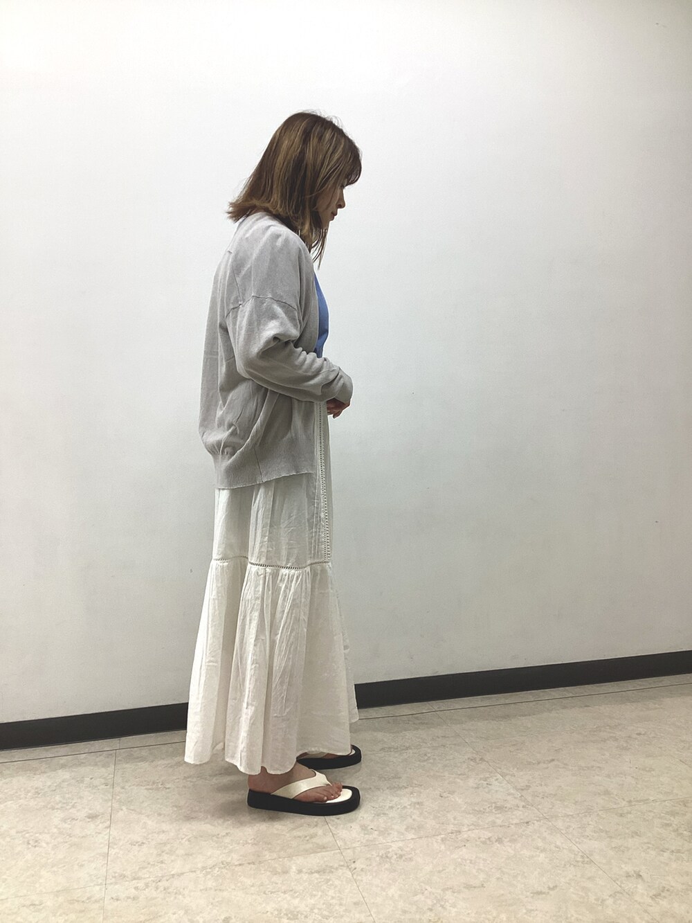 ブルー系のTシャツ/カットソー、グレー系のカーディガン/ボレロ、ホワイト系のスカートを着用したレディースの春コーディネートの3枚目の写真