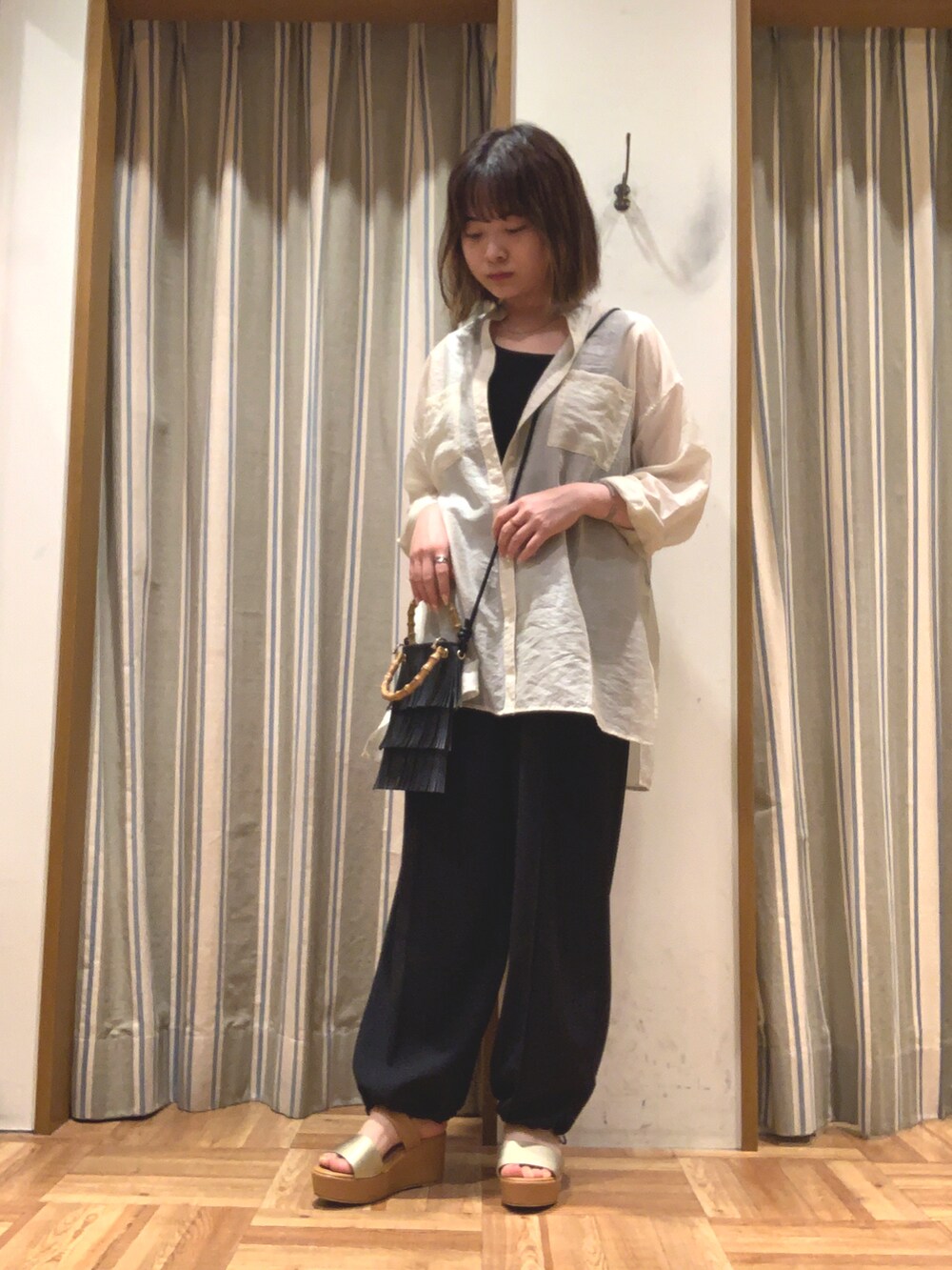 ホワイト系のシャツ/ブラウス、ブラック系のタンクトップ、ブラック系のハンドバッグを着用したレディースの夏コーディネートの2枚目の写真