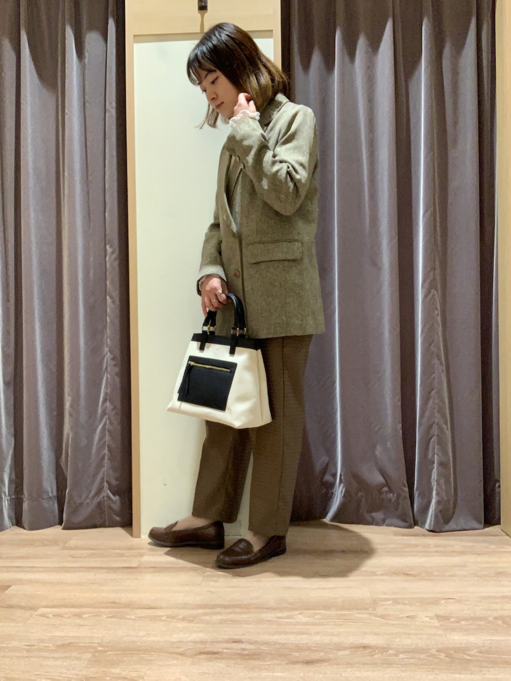 ホワイト系のTシャツ/カットソー、ブラウン系のテーラードジャケット、ホワイト系のハンドバッグを着用したレディースの秋コーディネートの3枚目の写真