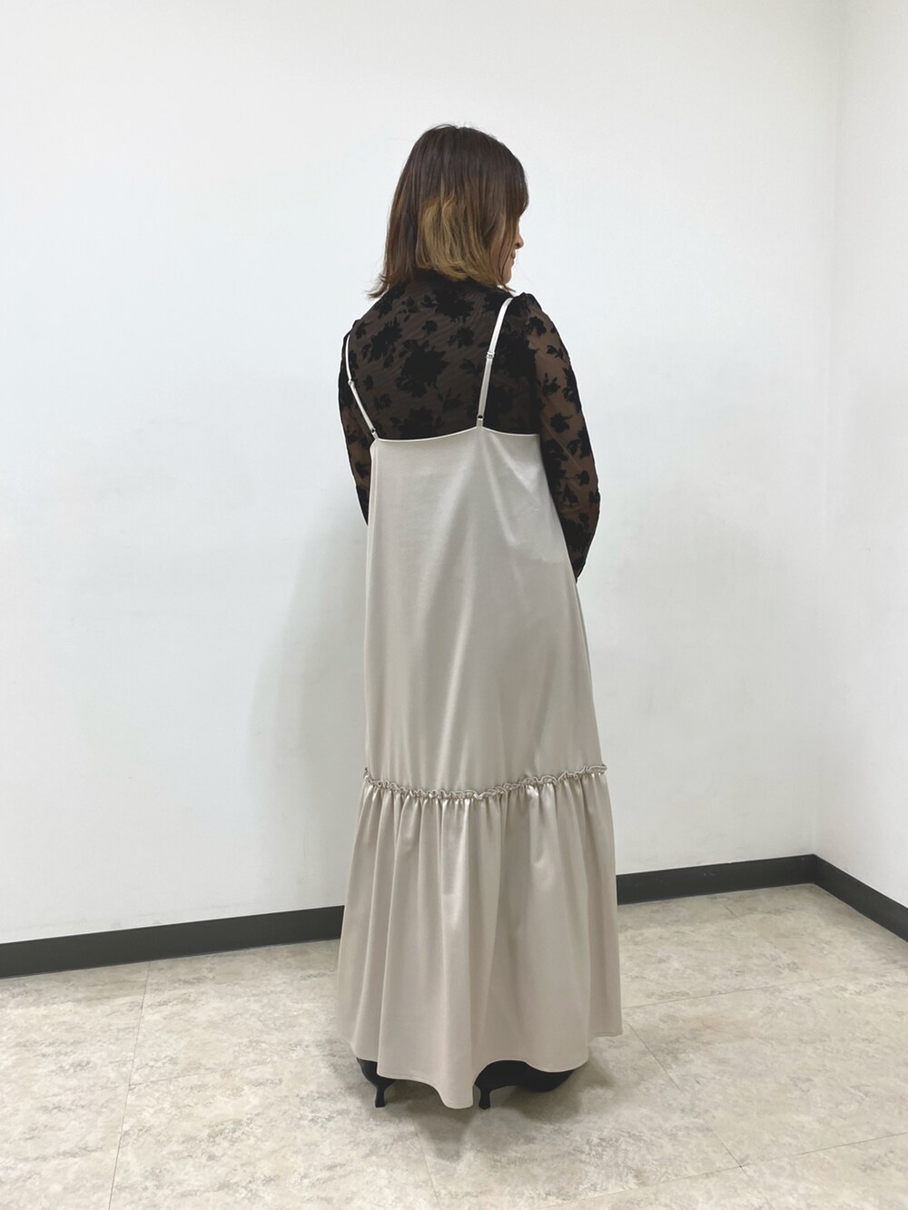 ブラウン系のTシャツ/カットソー、ベージュ系のワンピース、ブラック系のハンドバッグを着用したレディースの秋コーディネートの3枚目の写真