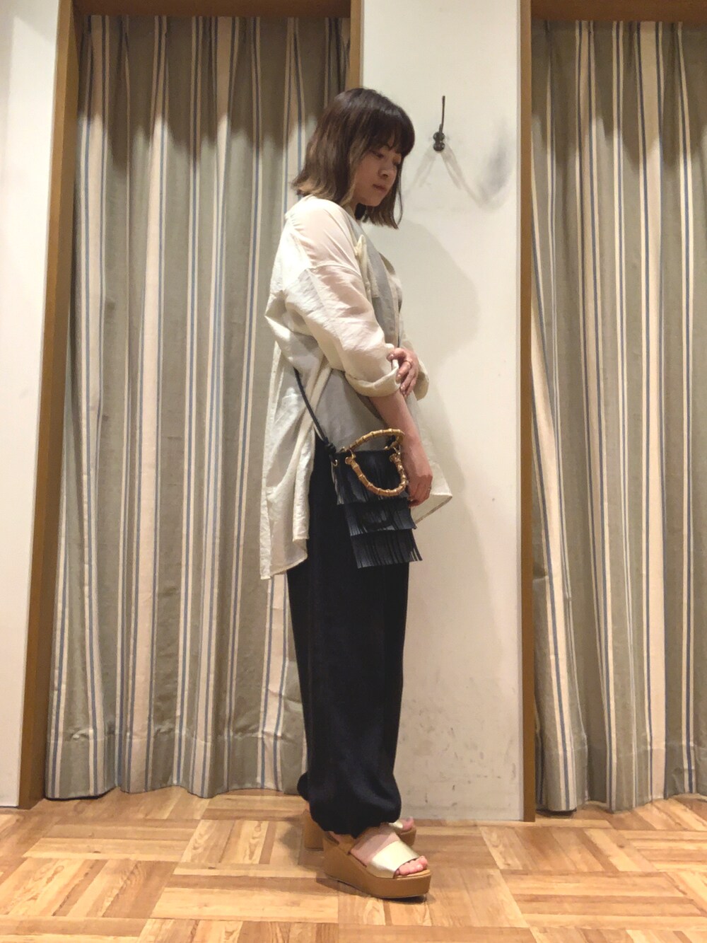 ホワイト系のシャツ/ブラウス、ブラック系のタンクトップ、ブラック系のハンドバッグを着用したレディースの夏コーディネートの3枚目の写真