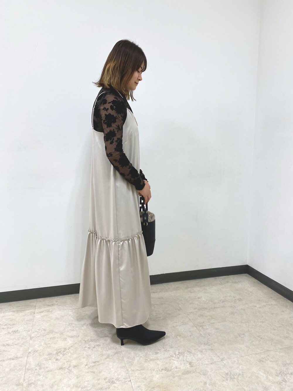 ブラウン系のTシャツ/カットソー、ベージュ系のワンピース、ブラック系のハンドバッグを着用したレディースの秋コーディネートの4枚目の写真