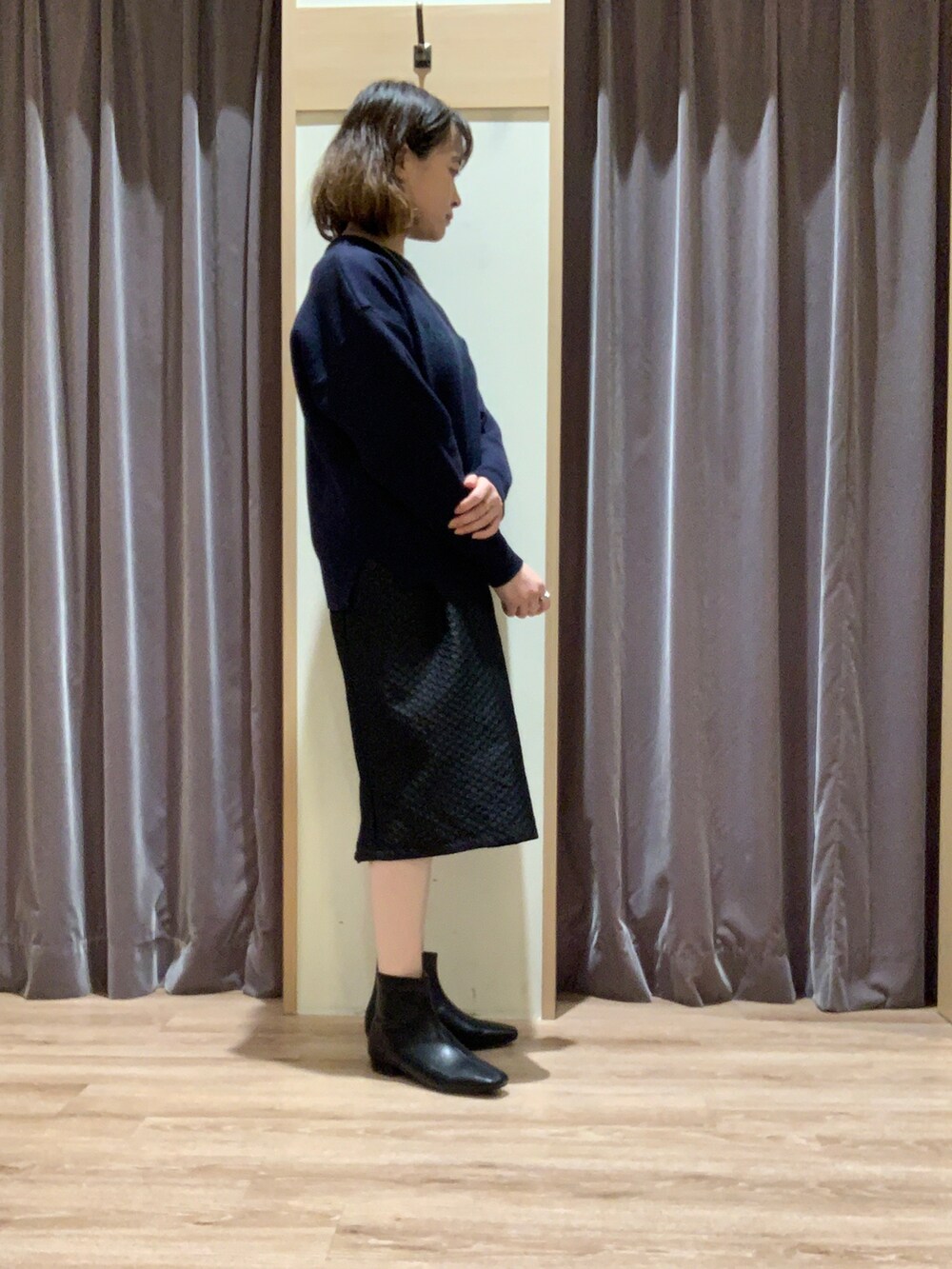 ブルー系のニット/セーター、ブラック系のスカート、ブラック系のブーツを着用したレディースの秋コーディネートの3枚目の写真