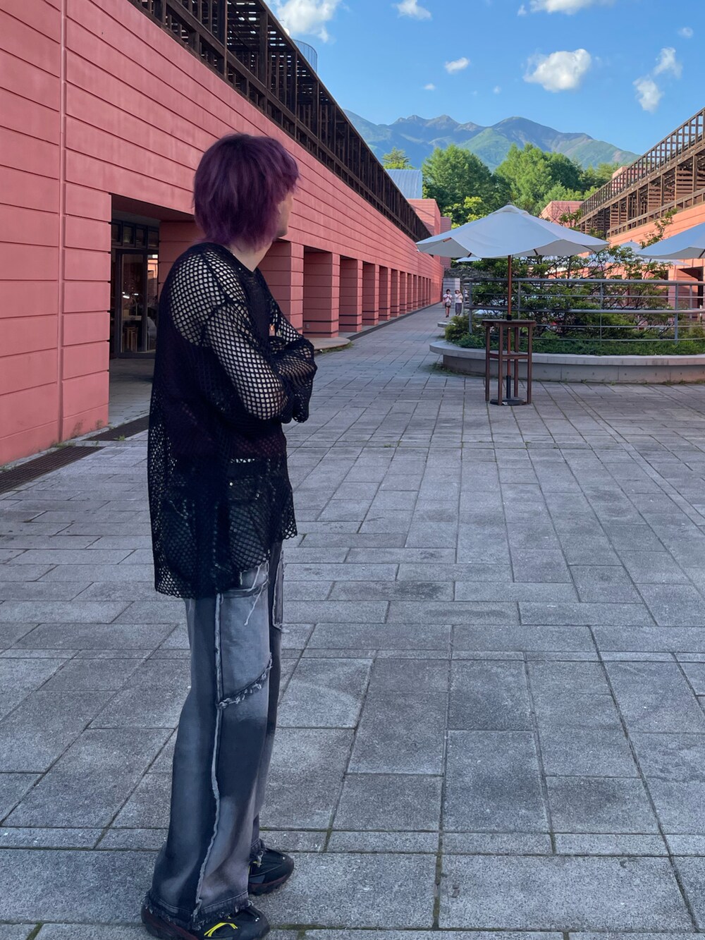 レッド系のタンクトップ、ブラック系のTシャツ/カットソー、ブラック系のデニムパンツを着用したメンズの夏コーディネートの2枚目の写真