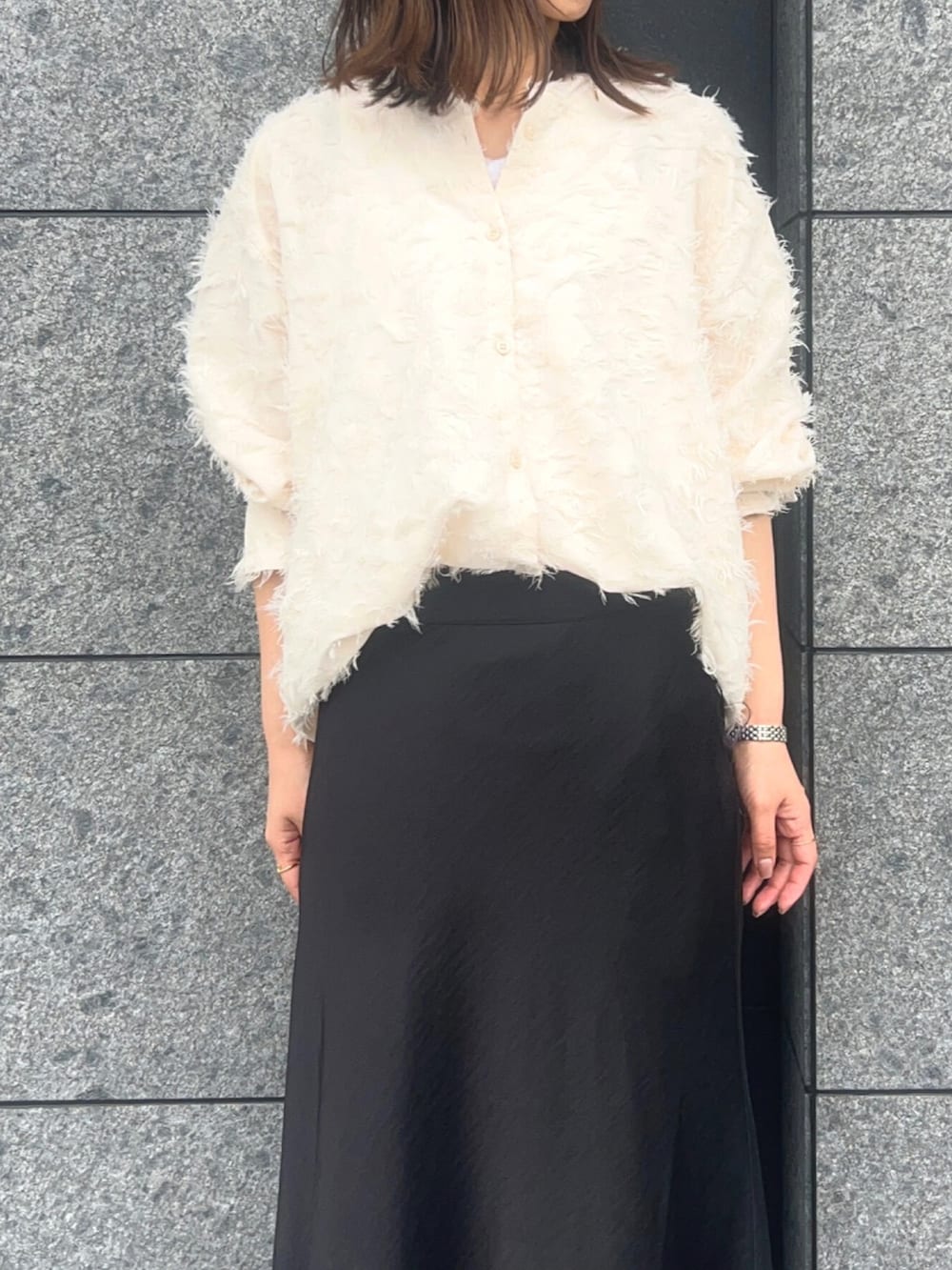 ブラック系のスカート、ホワイト系のタンクトップ、ホワイト系のシャツ/ブラウスを着用したレディースの春コーディネートの2枚目の写真