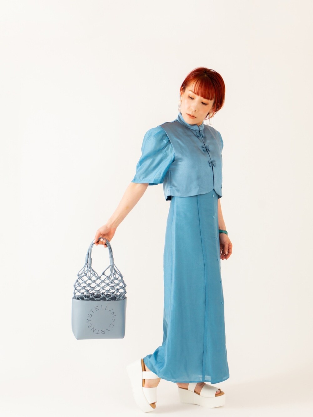 ブルー系のトートバッグ、ブルー系のワンピース、ホワイト系のサンダルを着用したレディースの春コーディネートの2枚目の写真