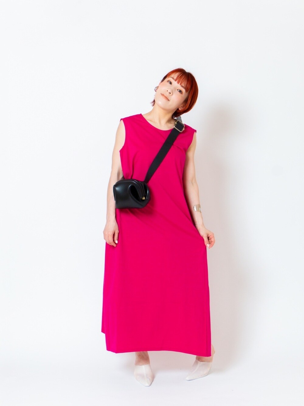 ピンク系のワンピース、ホワイト系のスリッポン、ブラック系のショルダーバッグを着用したレディースの春コーディネートの2枚目の写真