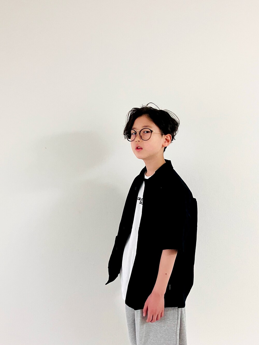 ホワイト系のTシャツ/カットソー、グレー系のスウェットパンツ、ブラック系のシャツ/ブラウスを着用したキッズの春コーディネートの3枚目の写真