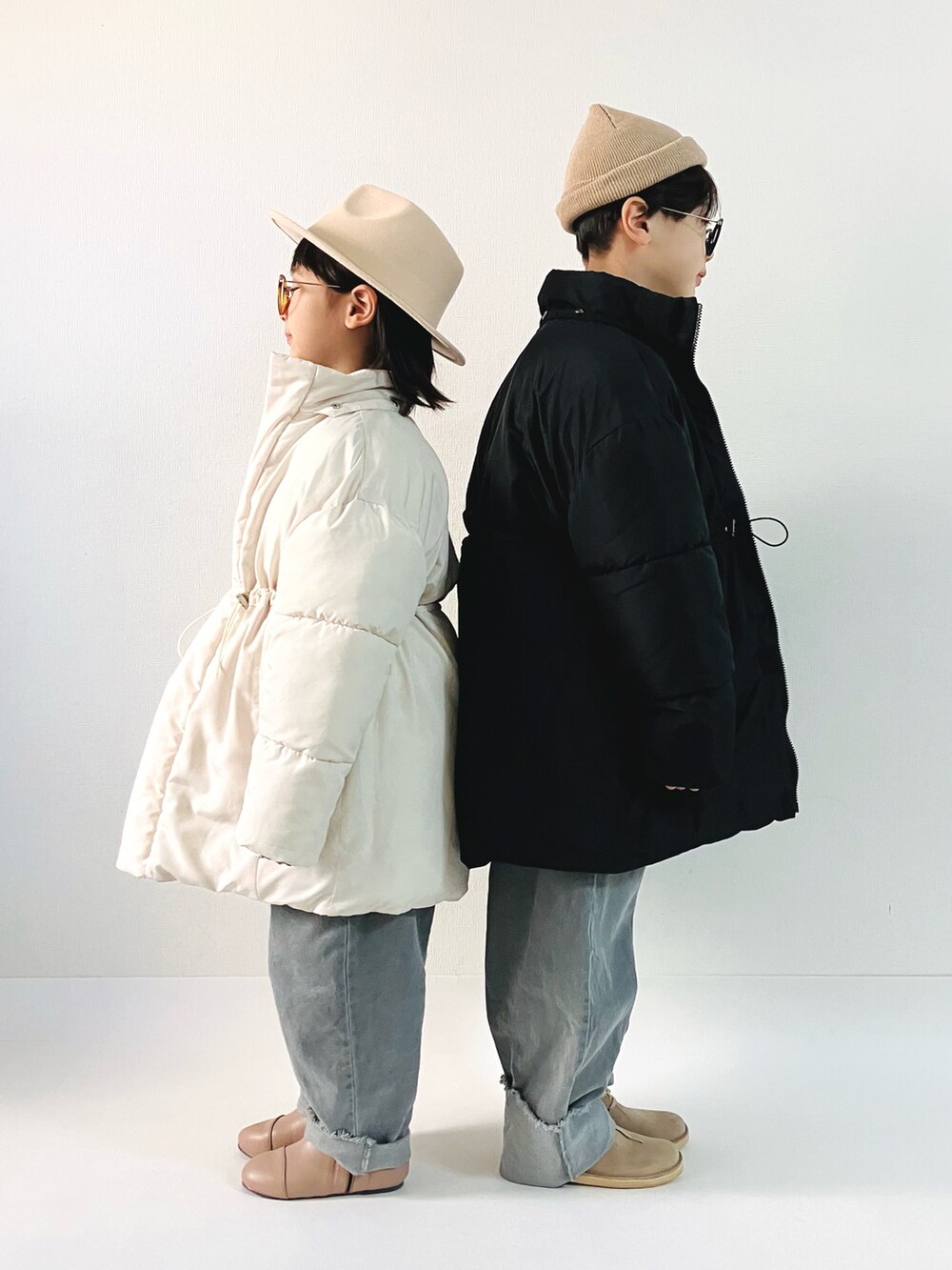 ホワイト系のダウンジャケット/コート、ブラック系のダウンジャケット/コート、グレー系のデニムパンツを着用したキッズの冬コーディネートの2枚目の写真