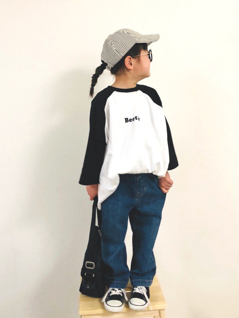 ブラック系のTシャツ/カットソー、ブルー系のデニムパンツ、ブラック系のスニーカーを着用したキッズの春コーディネートの2枚目の写真