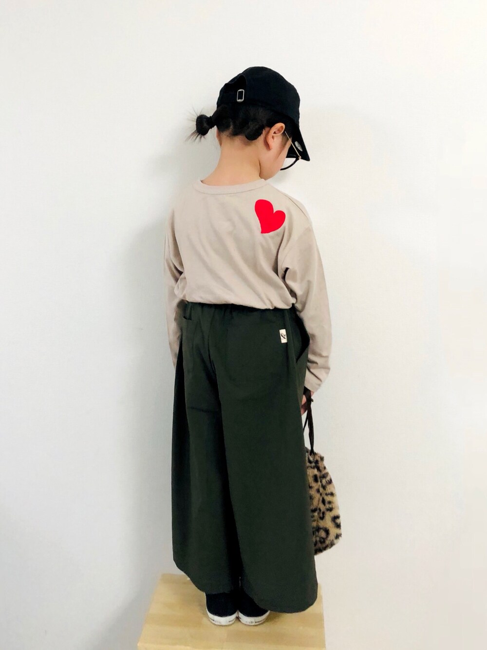 ベージュ系のTシャツ/カットソー、グリーン系のその他パンツ、ブラック系のスニーカーを着用したキッズの春コーディネートの3枚目の写真