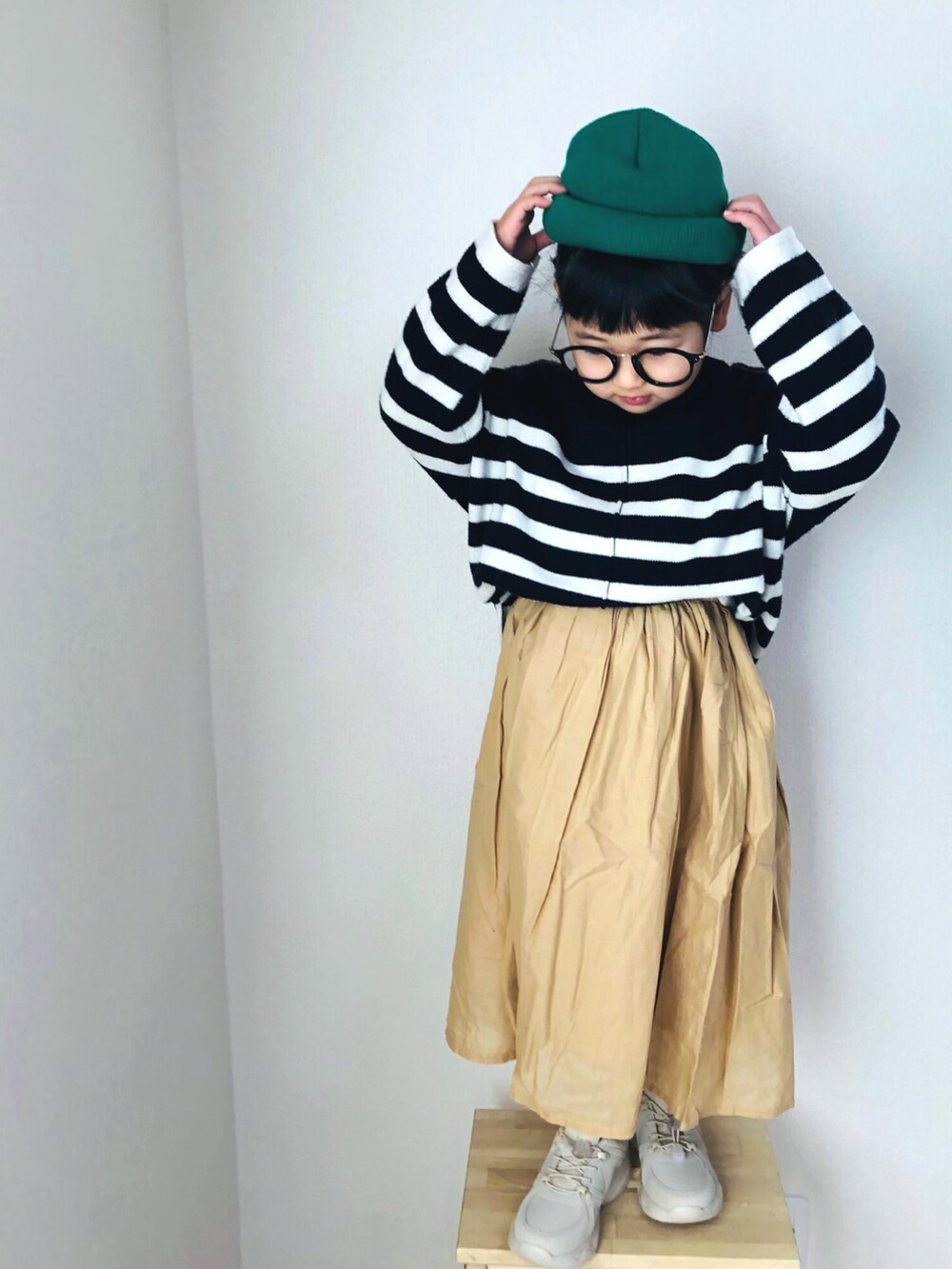 ホワイト系のニット/セーター、ベージュ系のスカート、ベージュ系のスニーカーを着用したキッズの冬コーディネートの4枚目の写真