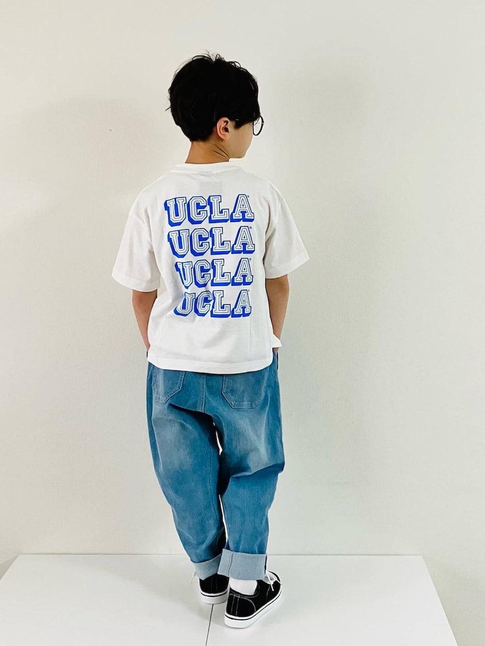 ホワイト系のTシャツ/カットソー、ブルー系のデニムパンツ、ブラック系のスニーカーを着用したキッズの春コーディネートの2枚目の写真