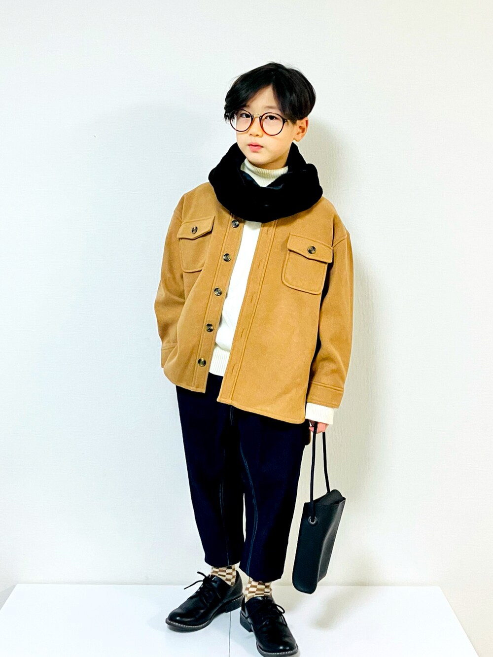 イエロー系のミリタリージャケット、ブルー系のデニムパンツ、ブラック系のローファーを着用したキッズの冬コーディネートの3枚目の写真