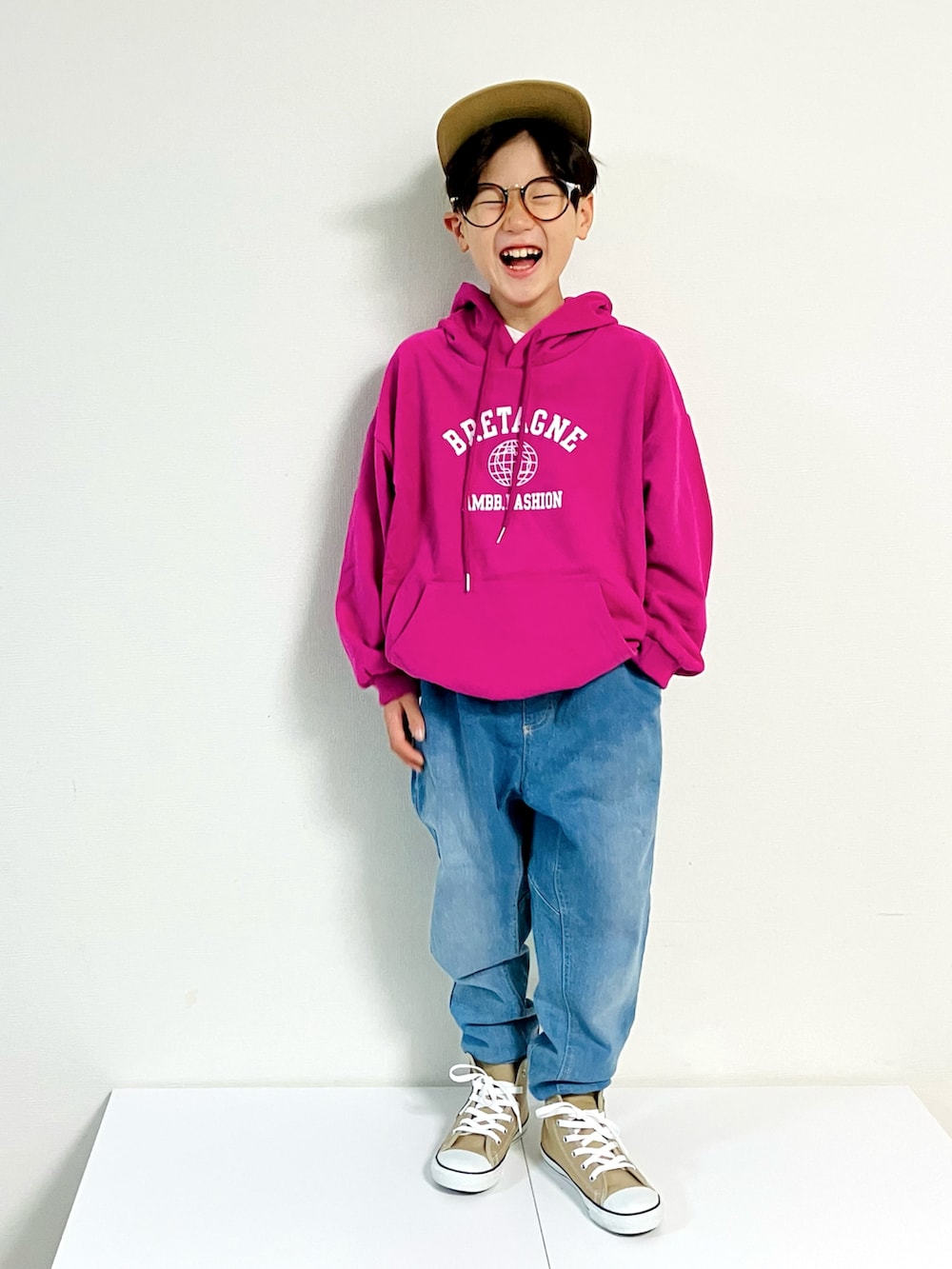 ピンク系のパーカー、ベージュ系のスニーカー、ブルー系のデニムパンツを着用したキッズの秋コーディネートの2枚目の写真