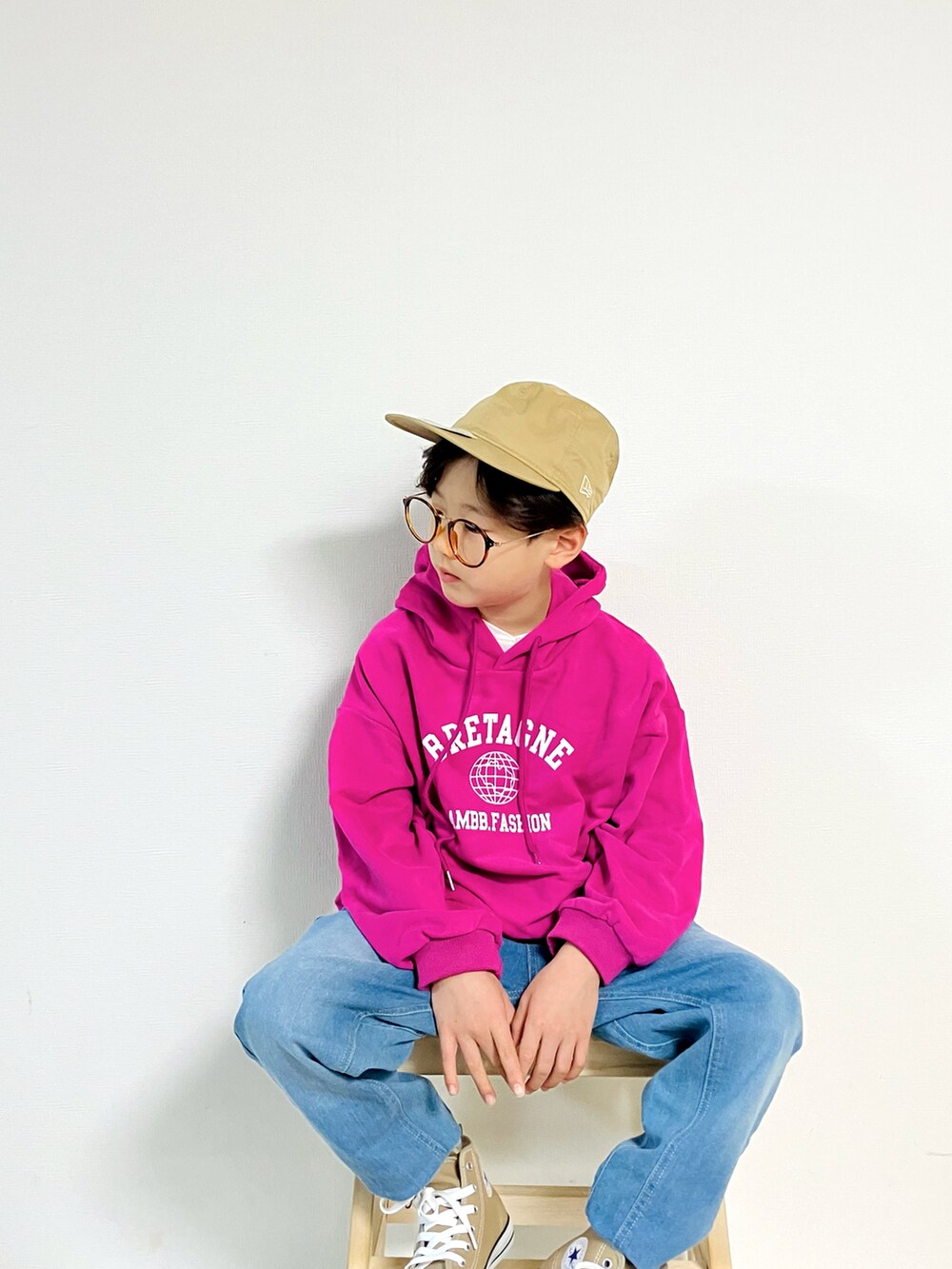 ピンク系のパーカー、ベージュ系のスニーカー、ブルー系のデニムパンツを着用したキッズの秋コーディネートの4枚目の写真