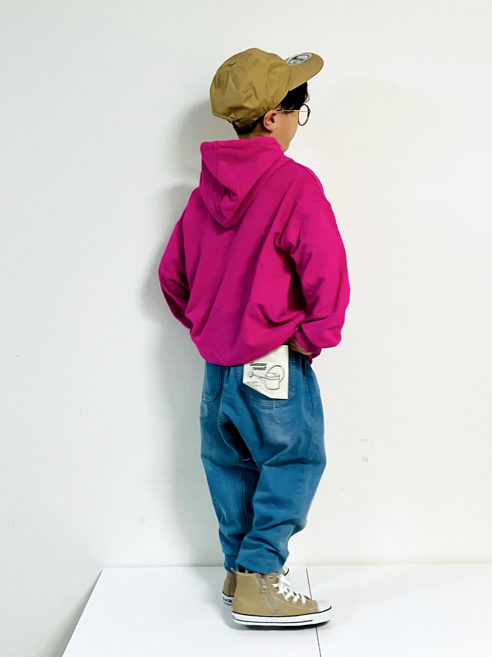 ピンク系のパーカー、ベージュ系のスニーカー、ブルー系のデニムパンツを着用したキッズの秋コーディネートの3枚目の写真