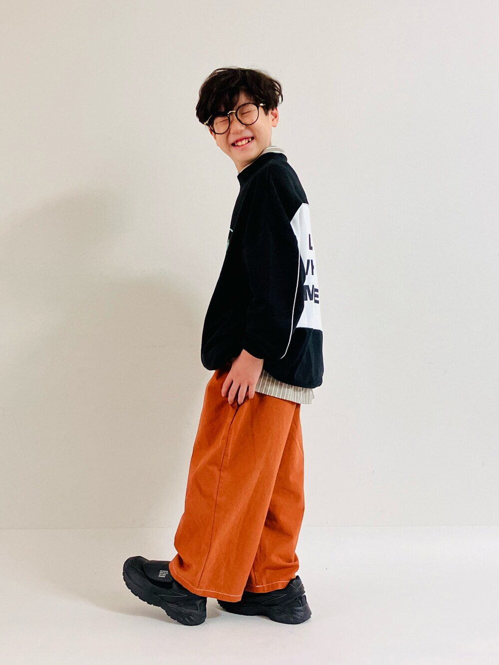 グリーン系のシャツ/ブラウス、ブラック系のスウェット、ブラック系のスニーカーを着用したキッズの秋コーディネートの2枚目の写真