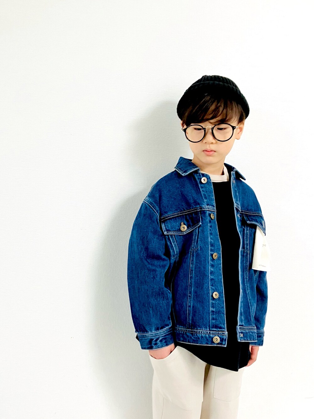 ブルー系のデニムジャケット、ホワイト系のその他パンツ、ブラック系のスニーカーを着用したキッズの秋コーディネートの3枚目の写真