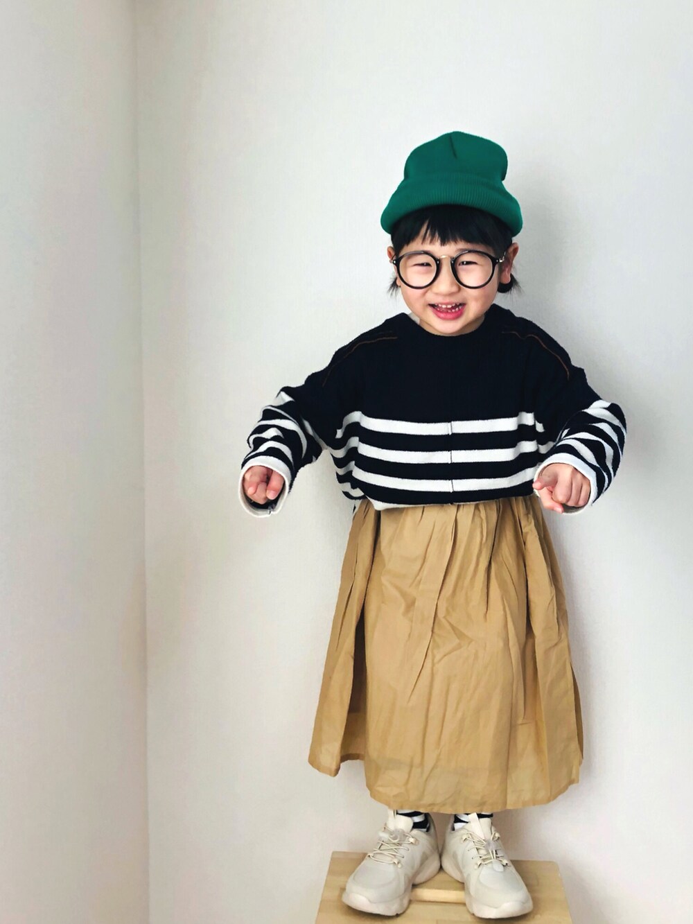 ホワイト系のニット/セーター、ベージュ系のスカート、ベージュ系のスニーカーを着用したキッズの冬コーディネートの3枚目の写真