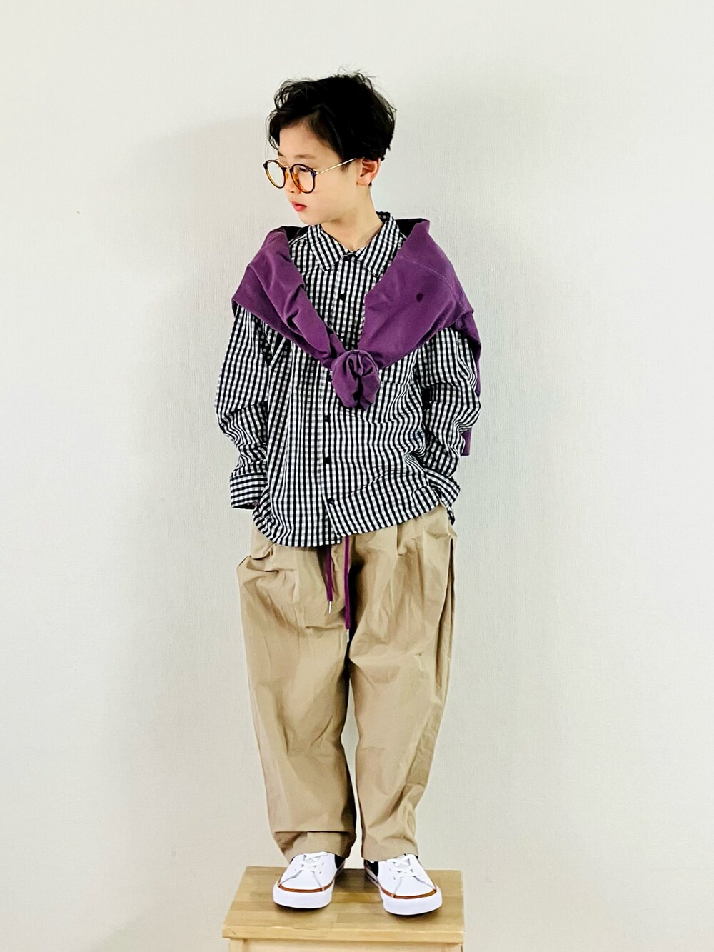 パープル系のTシャツ/カットソー、ベージュ系のパンツ、ホワイト系のスニーカーを着用したキッズの春コーディネートの4枚目の写真