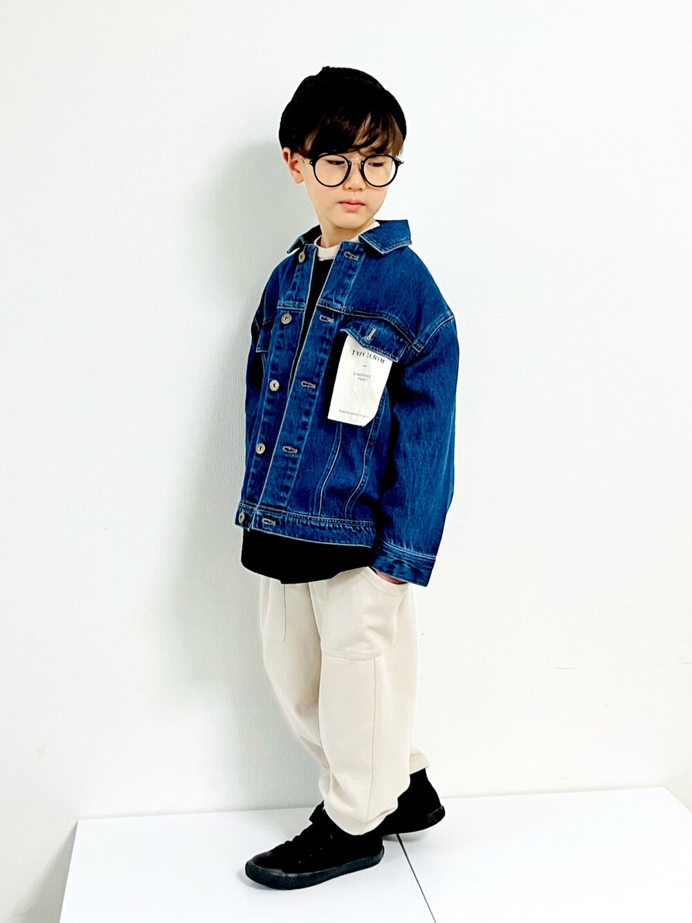 ブルー系のデニムジャケット、ホワイト系のその他パンツ、ブラック系のスニーカーを着用したキッズの秋コーディネートの2枚目の写真