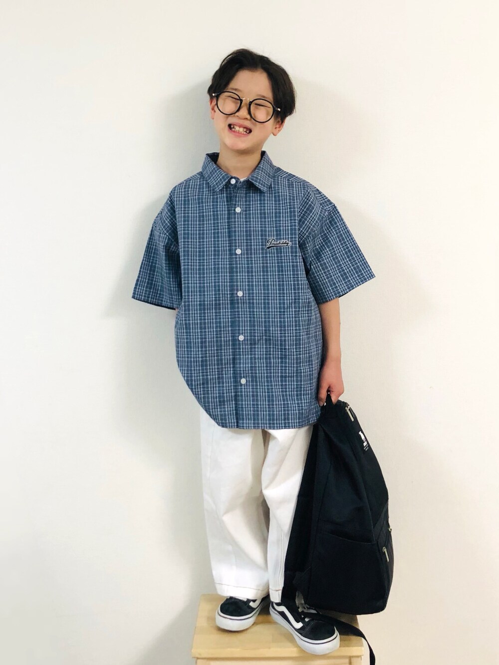 グレー系のシャツ/ブラウス、ホワイト系のデニムパンツ、ブラック系のスニーカーを着用したキッズの春コーディネートの5枚目の写真