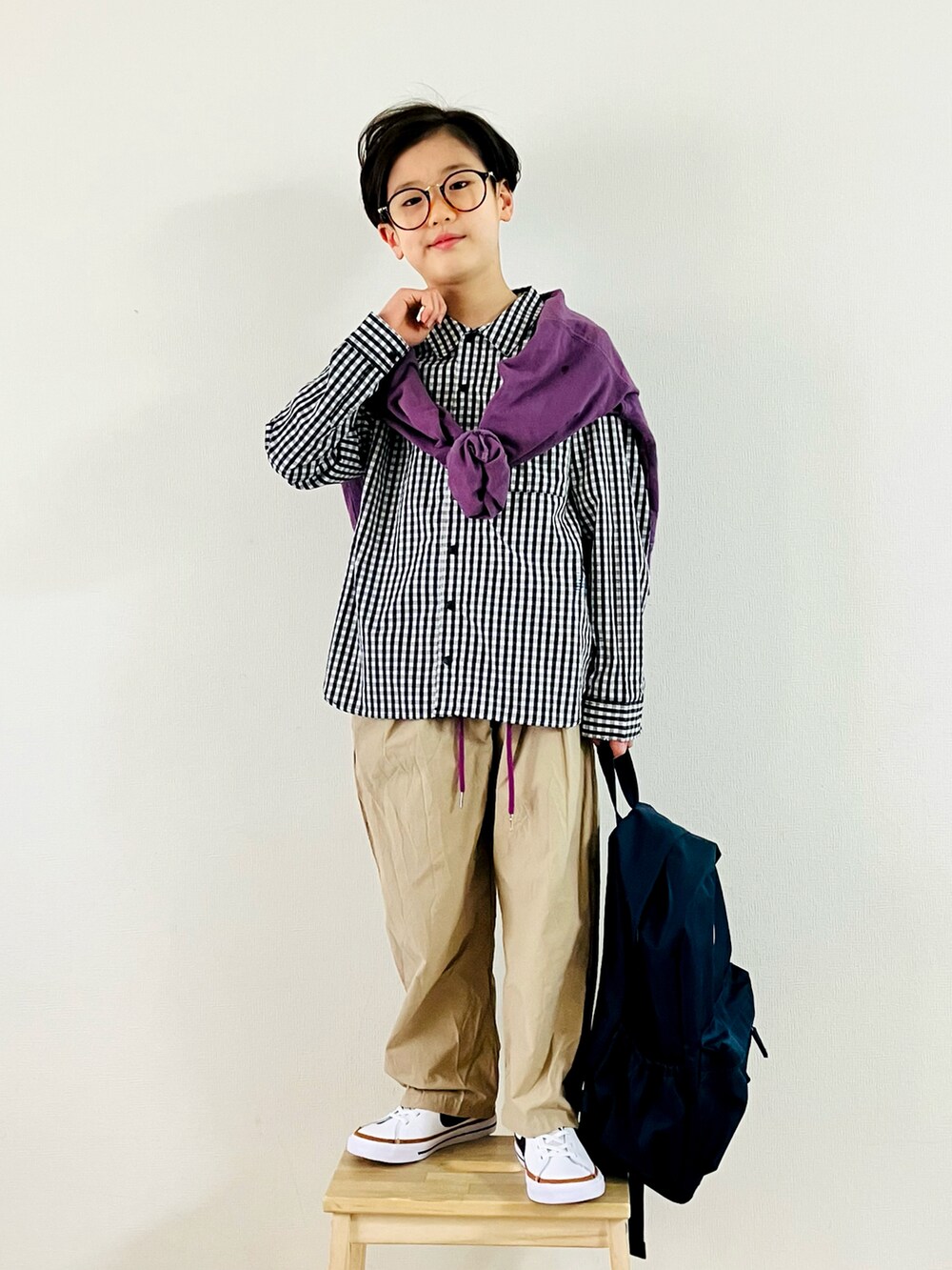 パープル系のTシャツ/カットソー、ベージュ系のパンツ、ホワイト系のスニーカーを着用したキッズの春コーディネートの3枚目の写真