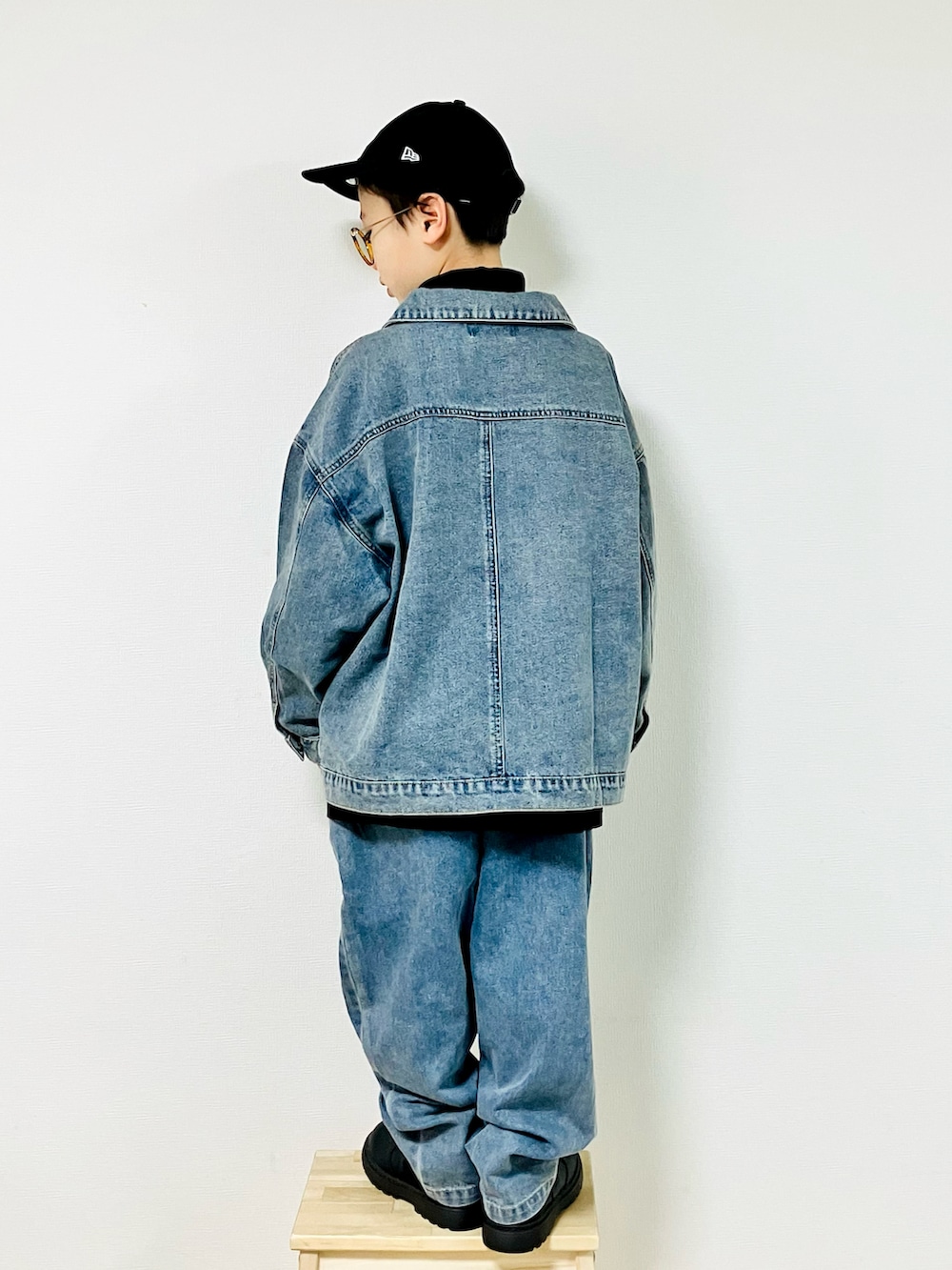 ブルー系のデニムジャケット、ブラック系のTシャツ/カットソー、ブルー系のデニムパンツを着用したキッズの冬コーディネートの4枚目の写真