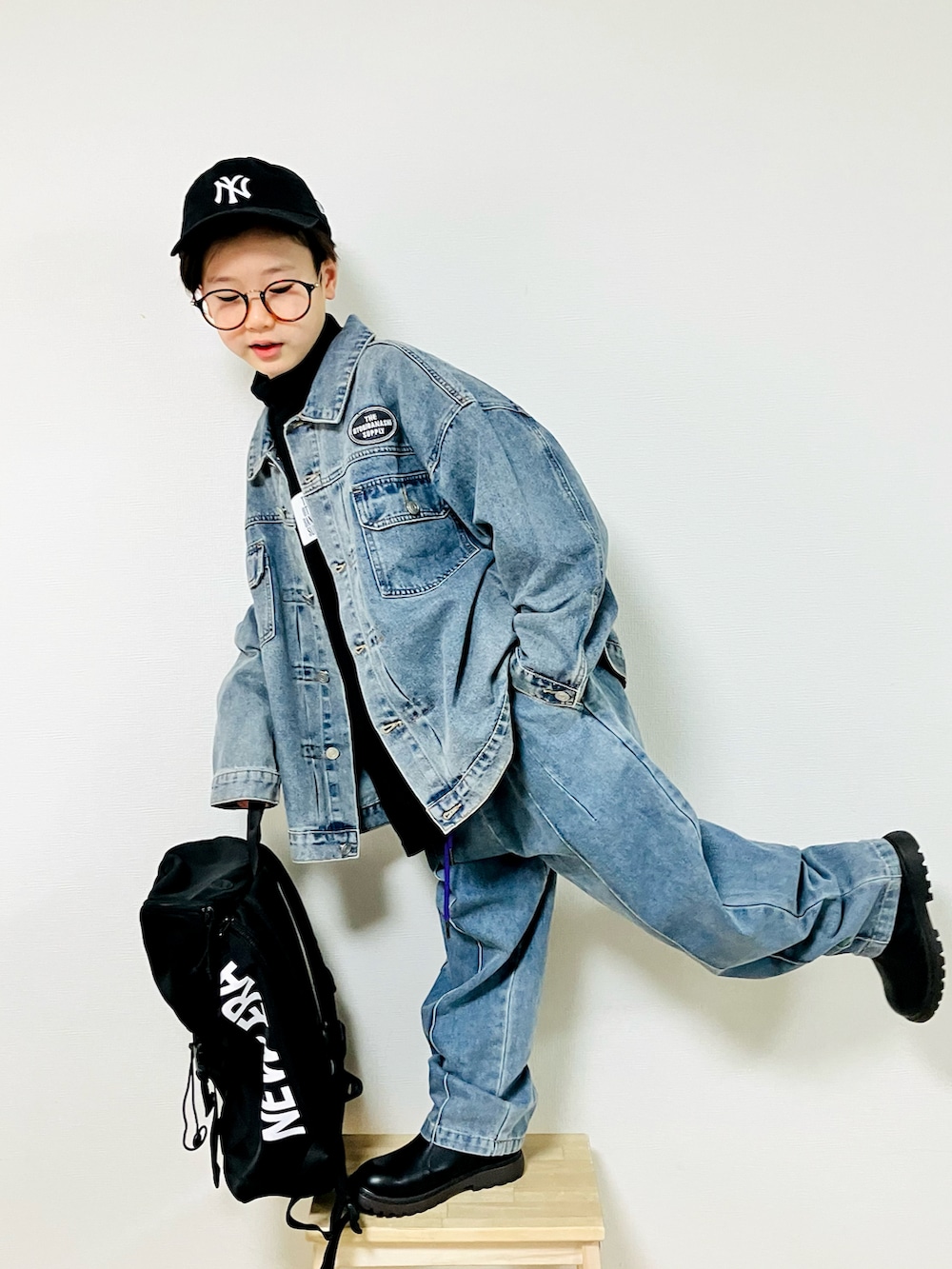 ブルー系のデニムジャケット、ブラック系のTシャツ/カットソー、ブルー系のデニムパンツを着用したキッズの冬コーディネートの3枚目の写真