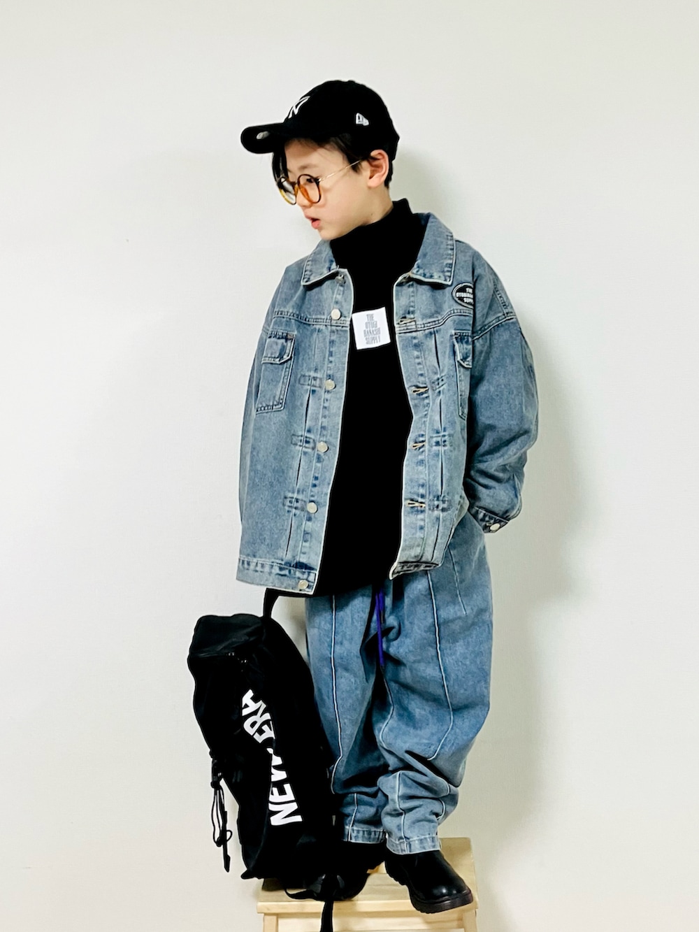 ブルー系のデニムジャケット、ブラック系のTシャツ/カットソー、ブルー系のデニムパンツを着用したキッズの冬コーディネートの2枚目の写真