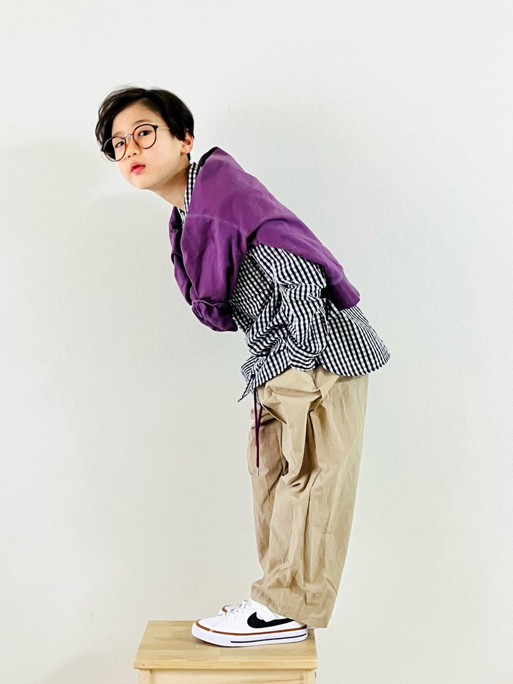 パープル系のTシャツ/カットソー、ベージュ系のパンツ、ホワイト系のスニーカーを着用したキッズの春コーディネートの2枚目の写真