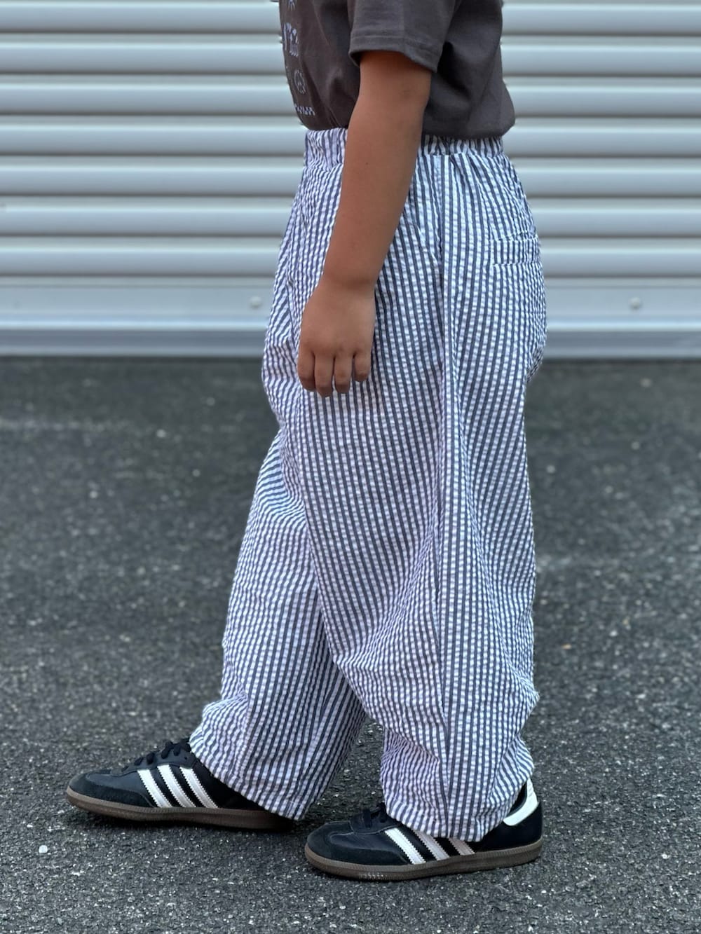 グレー系のその他パンツ、ブラック系のスニーカー、グレー系のTシャツ/カットソーを着用したキッズの夏コーディネートの3枚目の写真
