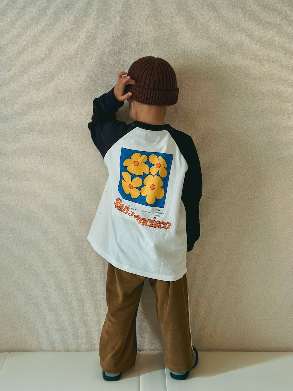 ホワイト系のTシャツ/カットソー、ベージュ系のパンツ、グリーン系のスニーカーを着用したキッズの春コーディネートの2枚目の写真