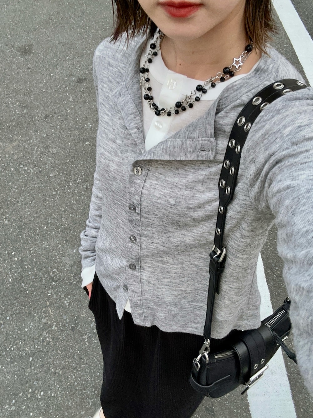 グレー系のカーディガン/ボレロ、ホワイト系のカーディガン/ボレロ、ブラック系のスカートを着用したレディースの春コーディネートの4枚目の写真