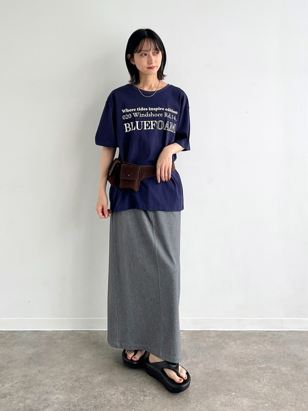 ブルー系のTシャツ/カットソー、グレー系のスカート、ブラック系のサンダルを着用したレディースの夏コーディネートの2枚目の写真