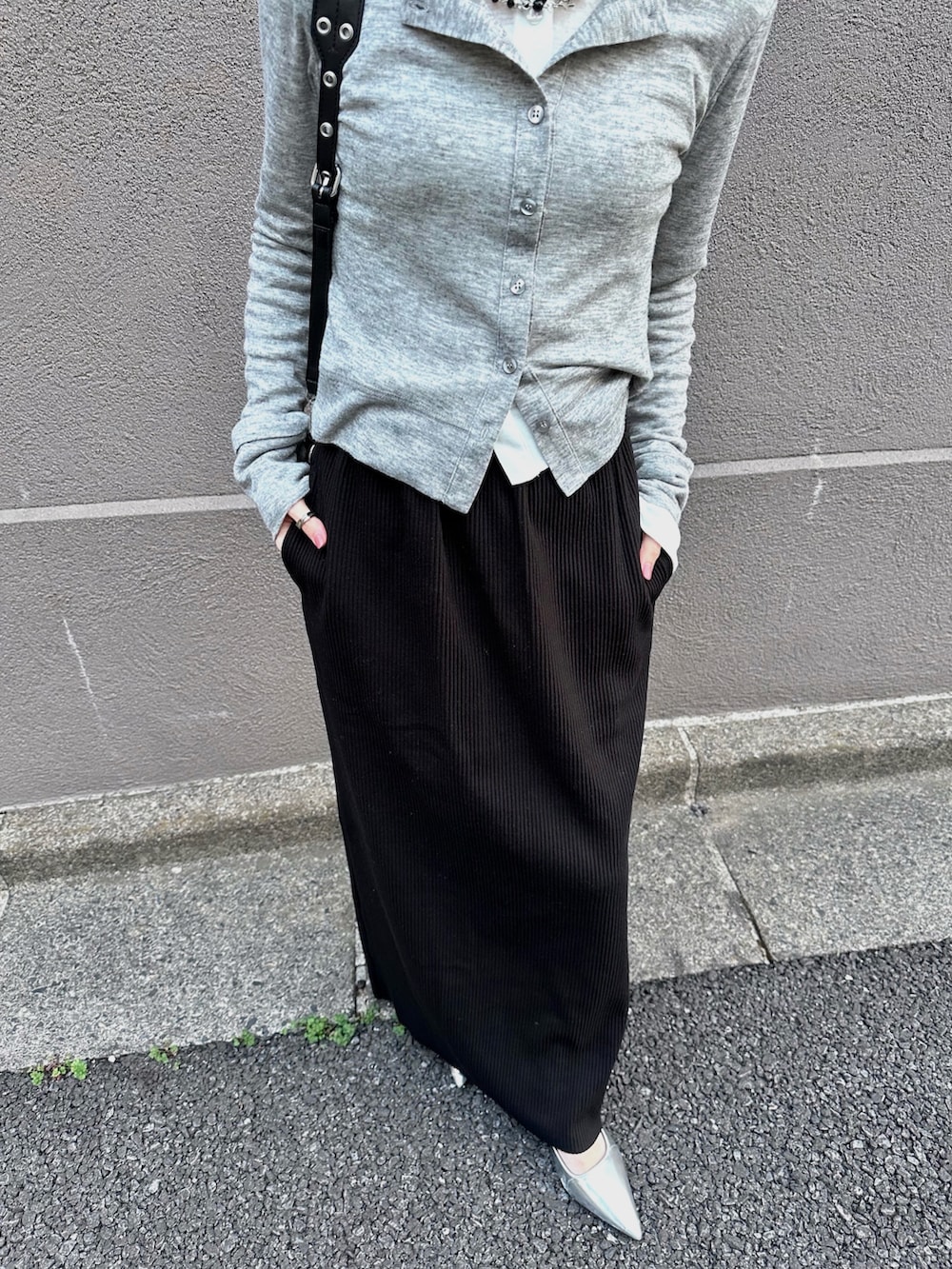 グレー系のカーディガン/ボレロ、ホワイト系のカーディガン/ボレロ、ブラック系のスカートを着用したレディースの春コーディネートの2枚目の写真